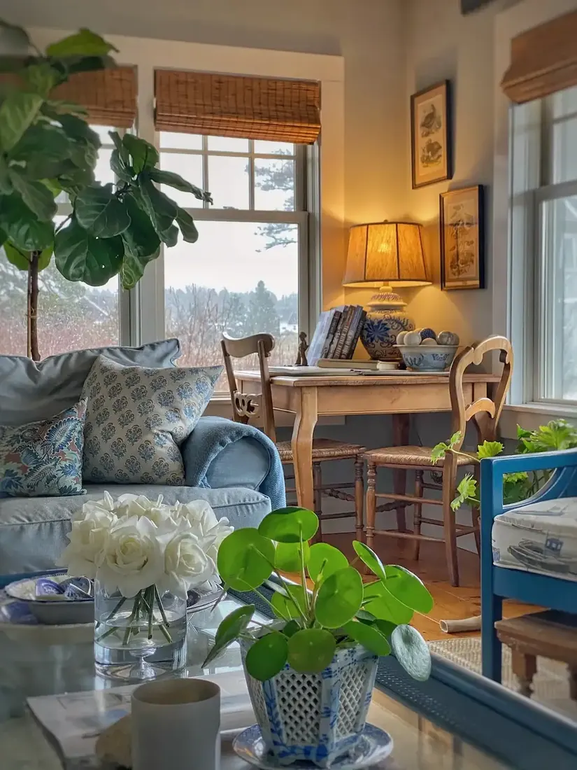 English cottage living room with floral curtains, striped chair and layered textiles