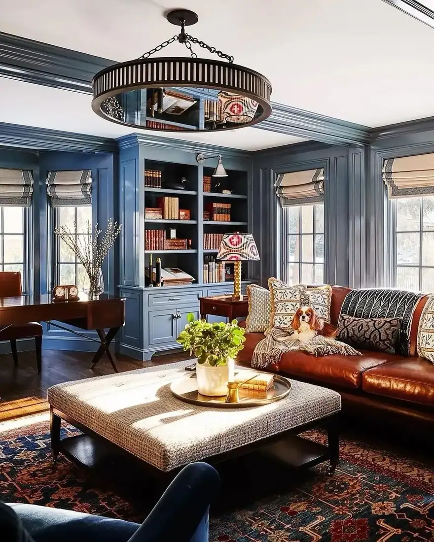 Moody blue living room built-ins with brass lights and warm styling