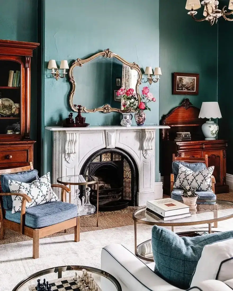Teal living room fireplace with mantel styled around a round mirror