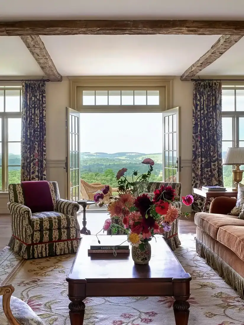 English country living room with floral chintz textiles, layered patterns and warm light