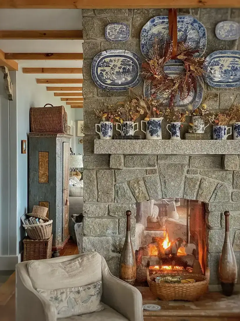 Blue and white transferware plates styled above a white fireplace mantel