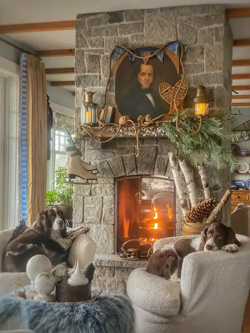 Stone fireplace decorated for Christmas with garland and warm lights