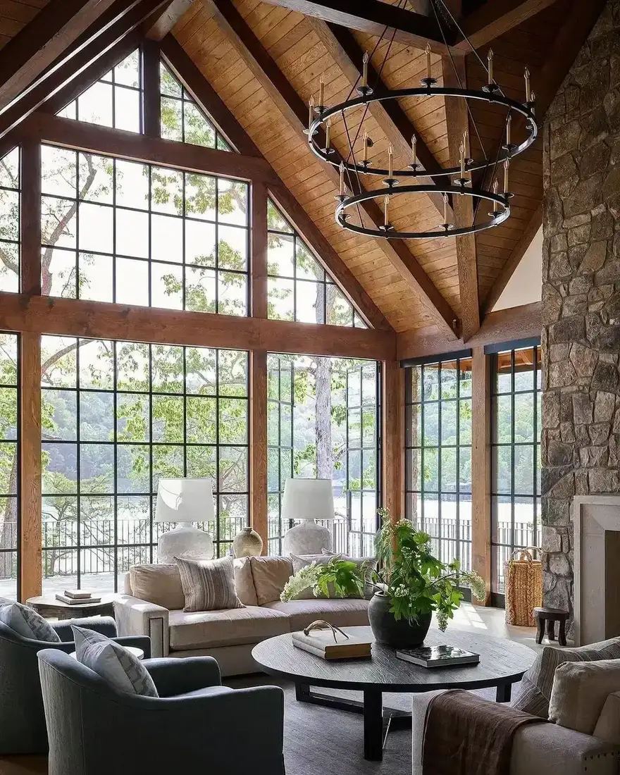 Modern rustic living room with wood ceiling, stone fireplace and layered textiles