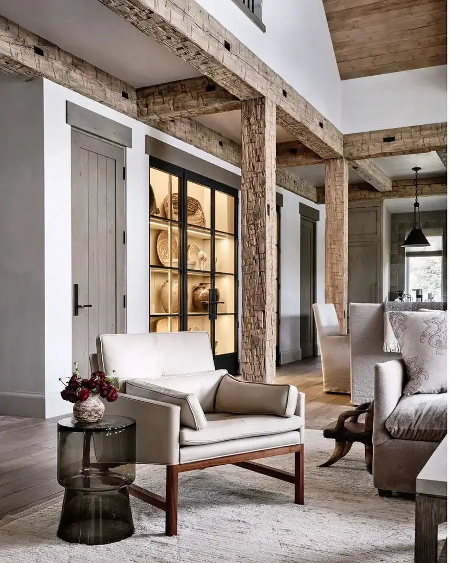 Rustic beam living room with glass cabinets, timber mantel and soft seating