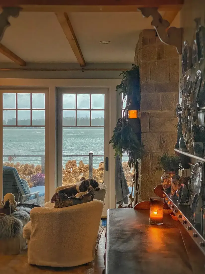 Rustic living room with stone fireplace, wooden mantel and layered textiles