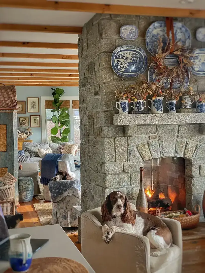 Stone fireplace with blue and white mantel styling and brass accents