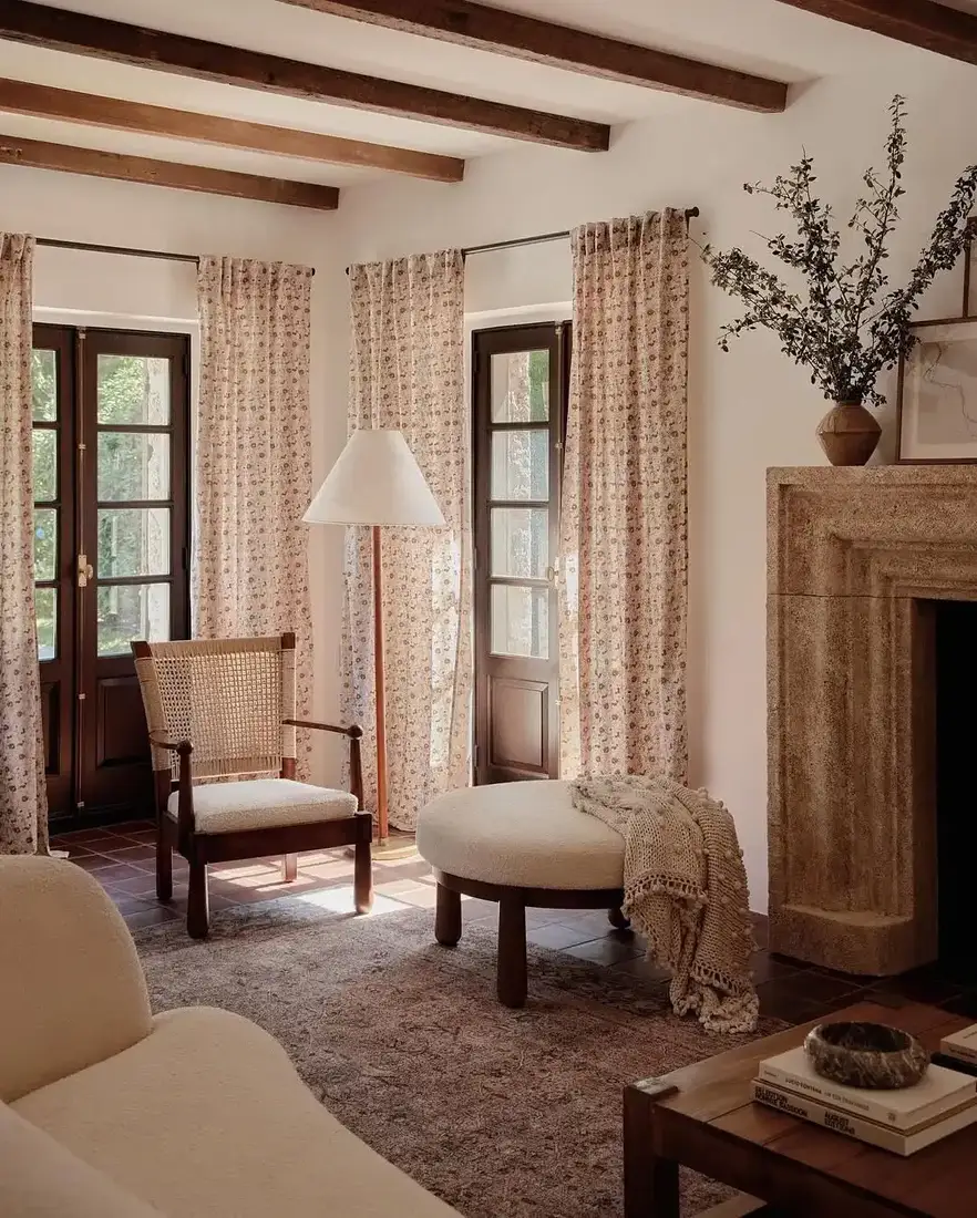 French country living room with stone fireplace, mantel decor and soft textiles