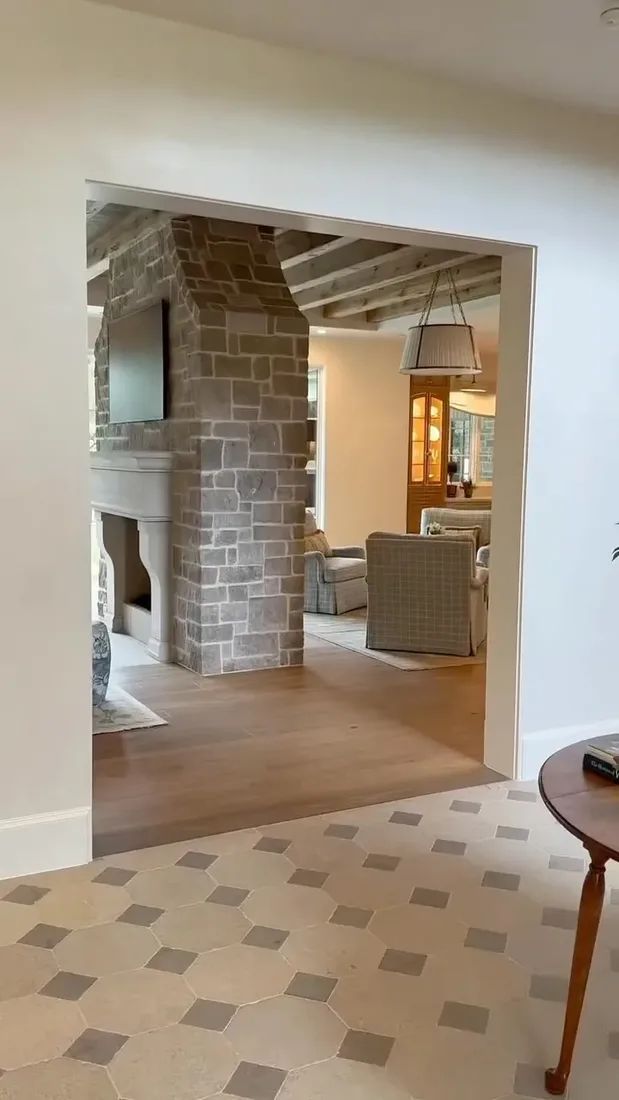 French country stone fireplace with wooden mantel and layered mantel styling