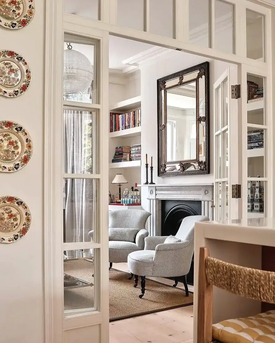 White living room with glass pocket doors and stone fireplace as a calm anchor