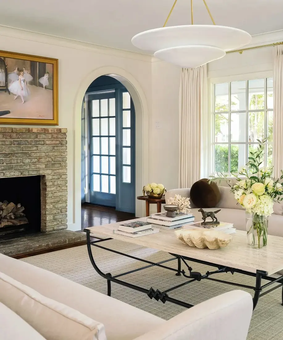 Neutral living room with brick fireplace, window seat and soft cushions