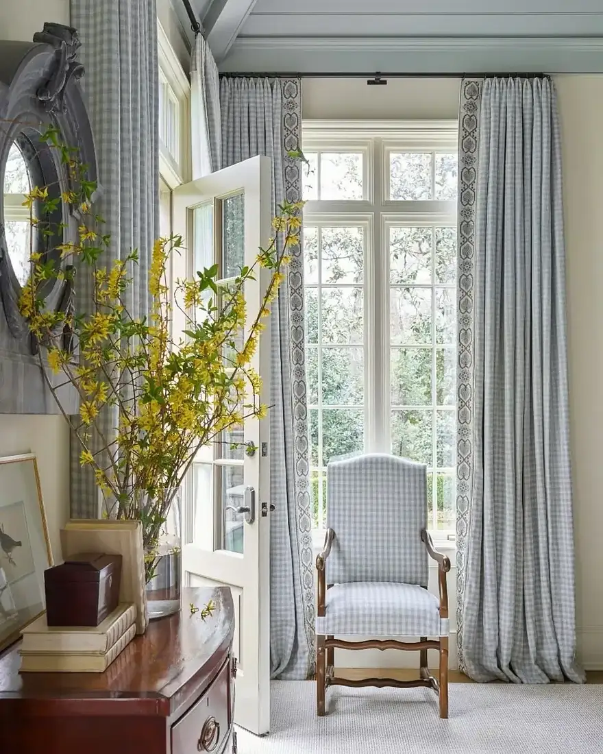 Bright sitting room with blue check curtains framing French doors