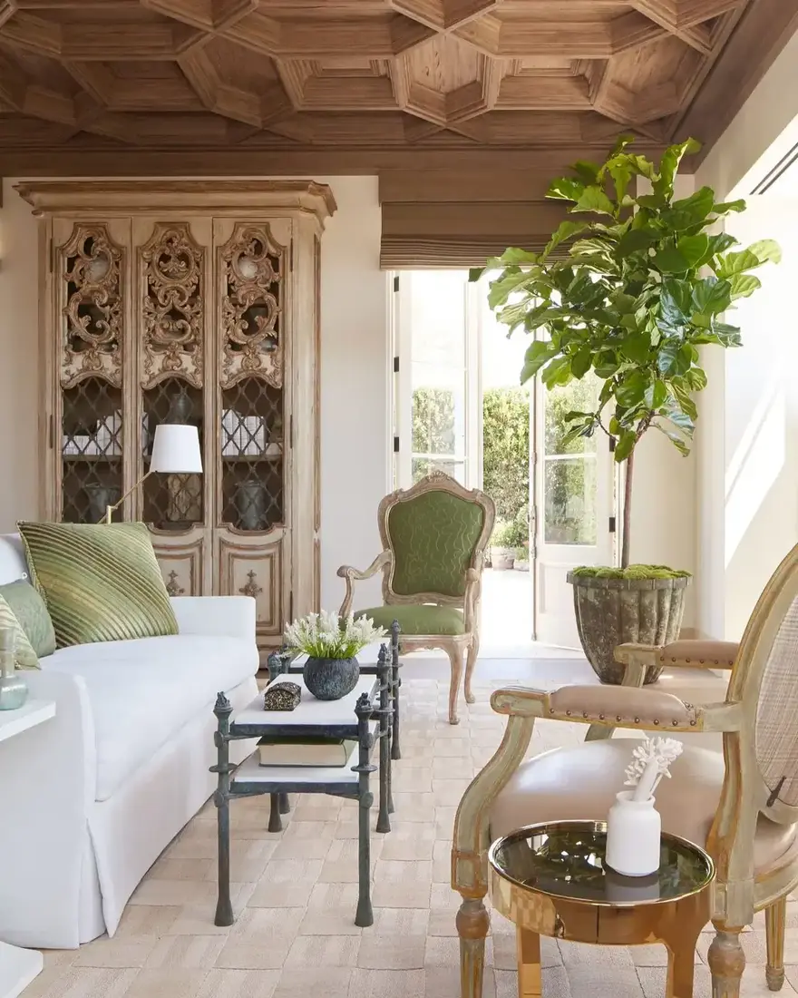 French antique sunroom with ornate carved ceiling and tall windows
