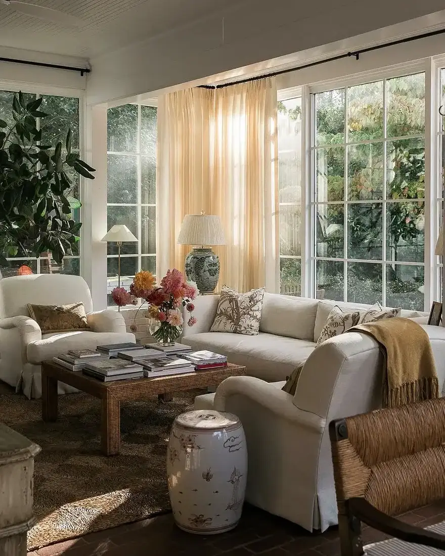 Sunroom with slipcovered sofa and relaxed linen curtains
