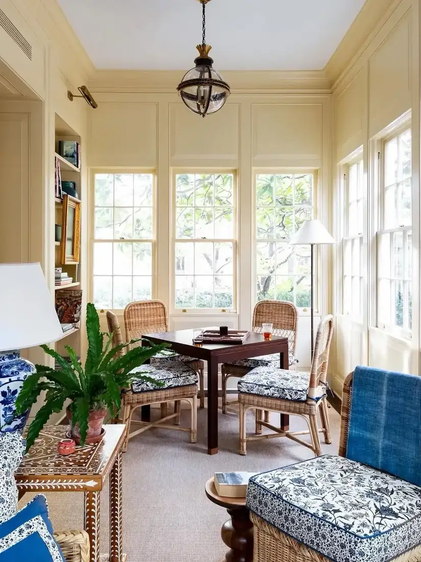 Traditional blue and white sunroom with wicker chairs and cushions