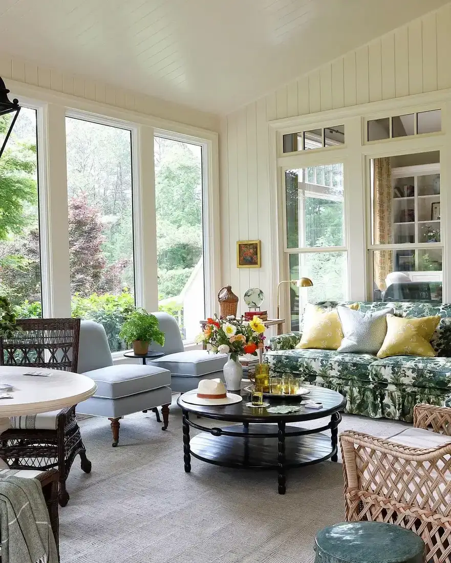 Traditional sunroom with floral chintz sofa and classic side tables
