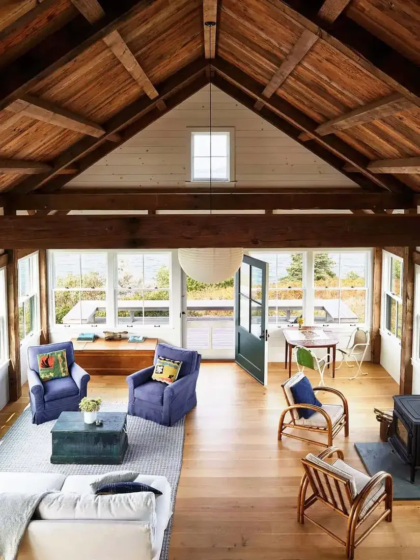 Cozy timber beam living room with fireplace, timber mantel and soft lighting