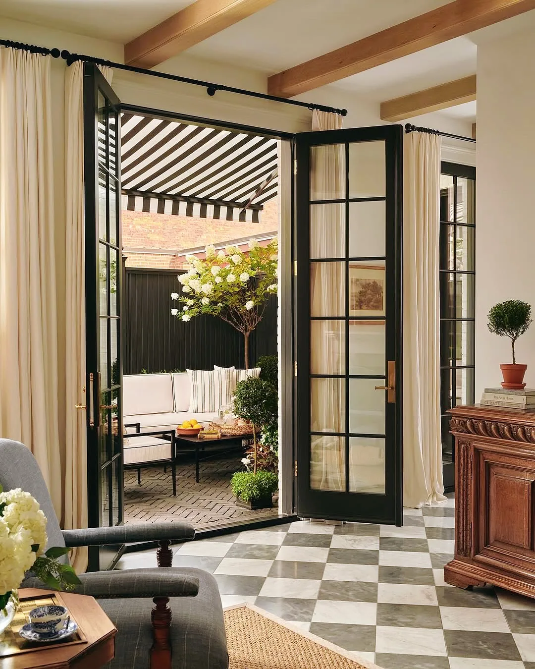 Traditional living room with black French doors and a checkered floor