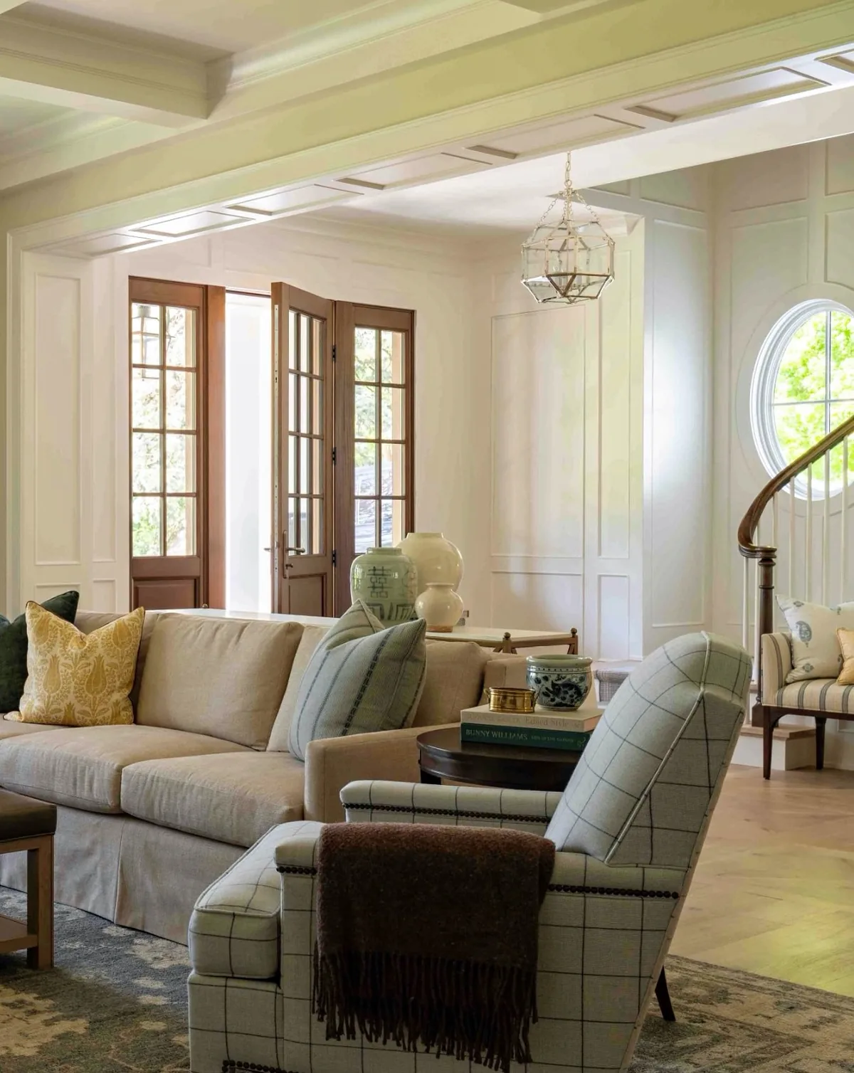 Cream living room with a plaid chair and French doors