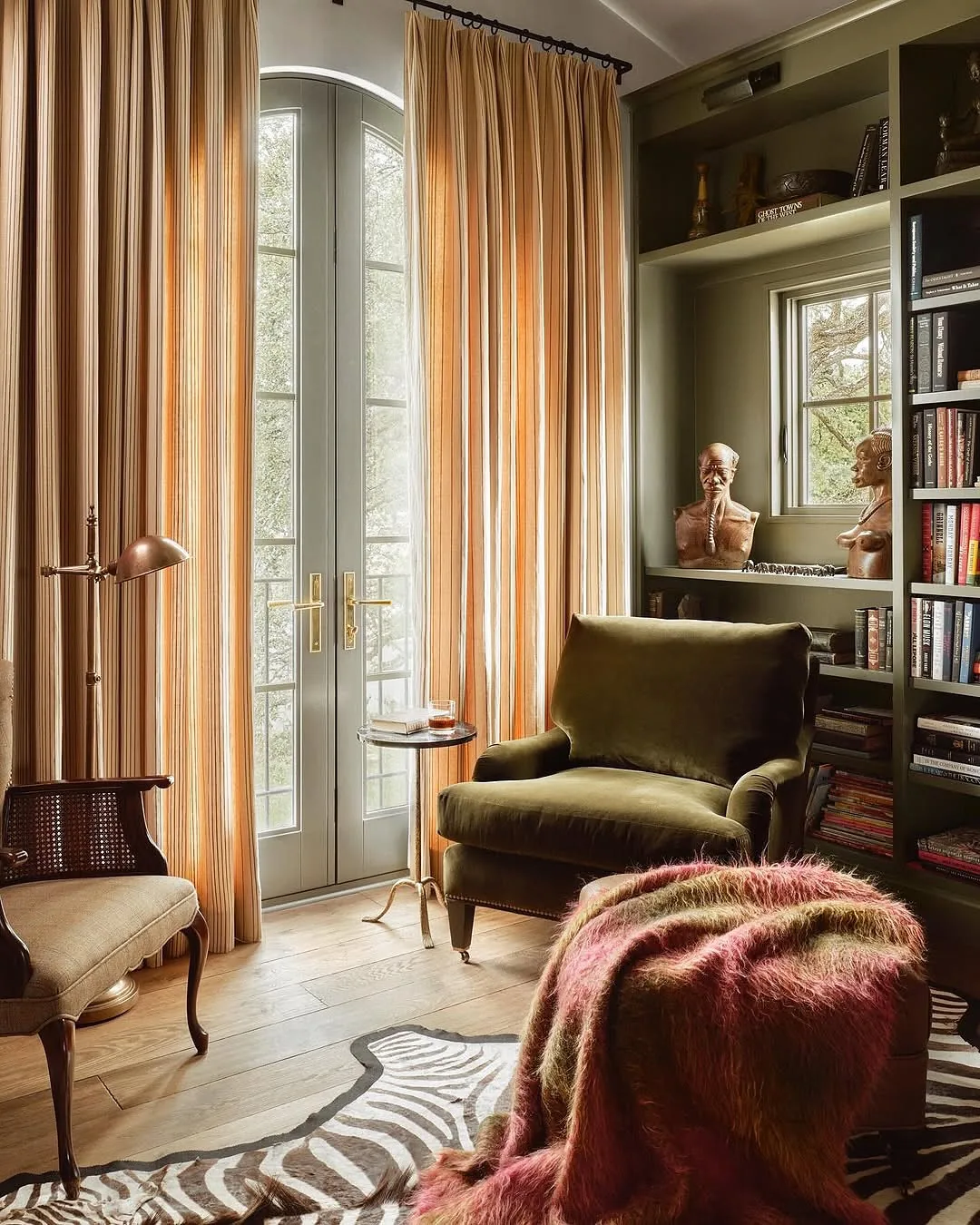 Cozy olive green reading nook with a chair and lamp