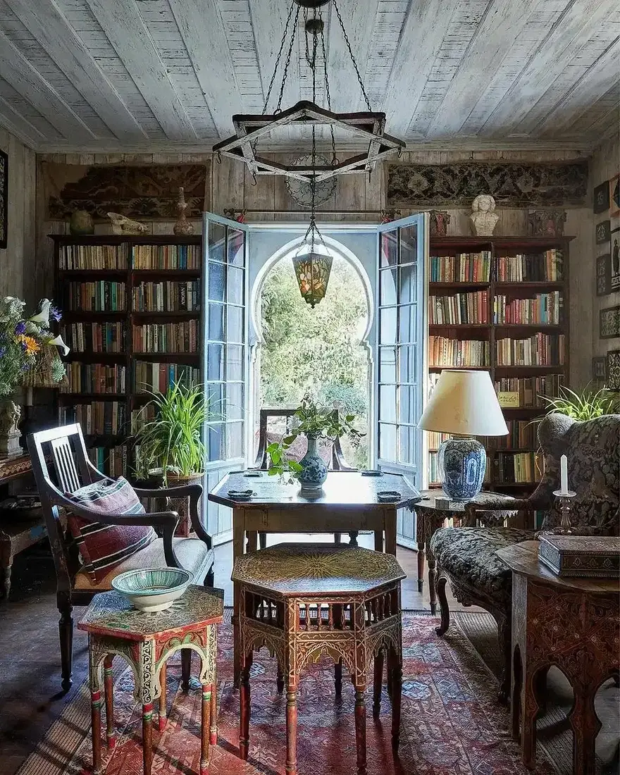 Vintage eclectic home library with warm colour and collected shelves