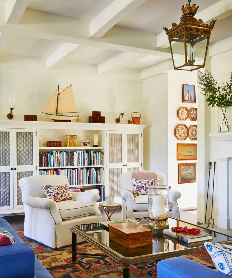 White living room built-in bookshelves with lantern and warm decor