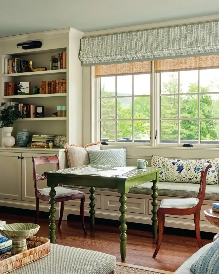 Built-in bookshelves with window seat and green side table by window